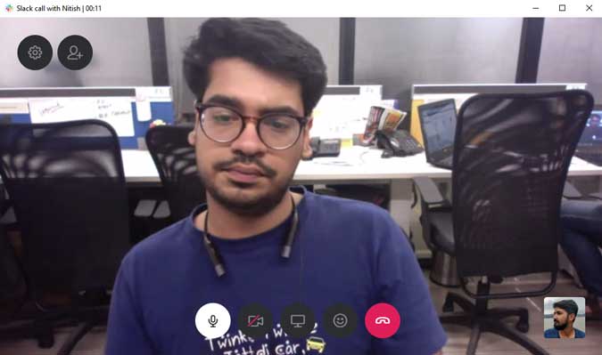 Nitish video calling Kaushal on Slack with some chairs and office equipment in the background